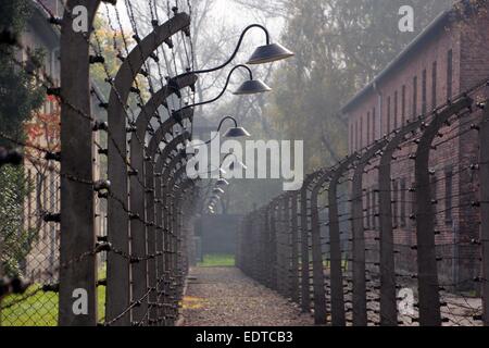 A double barbed wired fence surrounds the main camp of Auschwitz concentration camp in Oswiecim, Poland, 4 October 2014. The fence was powered with a high-voltage current. The building (L) outside the camp accommodated the offices of the camp administration. The camp was liberated by Soviet troops on 27 January 1945 and was turned into a memorial site and museum in 1947. The camp has been since 2007 A listed UNESCO heritage site official titled as 'Auschwitz-Birkenau - German national socialist concentration and extermination camp. Photo: Frank Schumann/dpa - NO WIRE SERVICE - Stock Photo