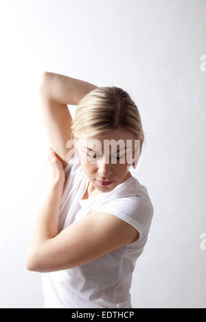 Woman in T-shirt Twisting Arms Stock Photo