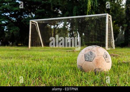 Old football on lawn in rural school Stock Photo