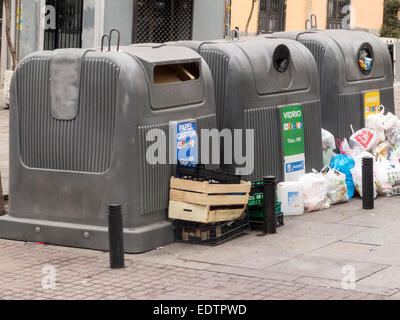 MADRID, SPAIN - DECEMBER 27, 2014: containers for recycling on the street surrounded by trash. Stock Photo