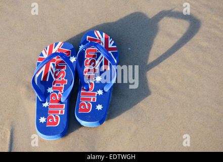 Australian sandals flip flops thongs with Australian flag on wide sandy beach in early morning sun. Taken in South Australia. Stock Photo