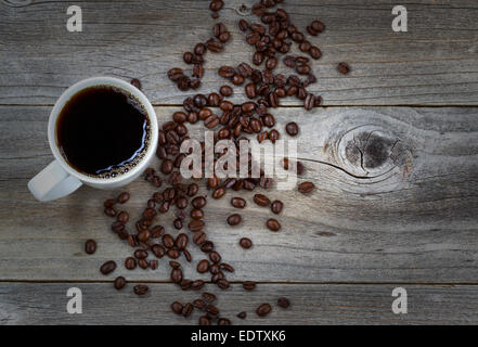 Top view image of fresh dark coffee and premium roasted whole beans on rustic wood with slight vignette border Stock Photo