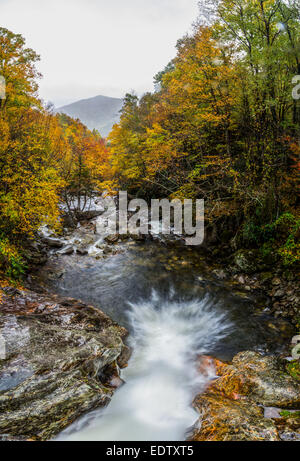 Water pours over a cascade in a long exposure shot taken from above in autumn Stock Photo