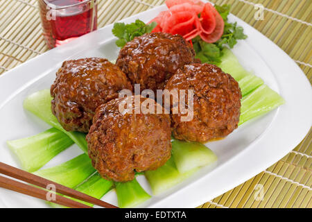 Horizontal image of large freshly cooked meatballs and vegetables with a glass of red wine Stock Photo
