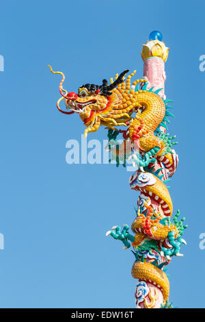 The old statue of gold dragon bind pillar and blue sky Stock Photo