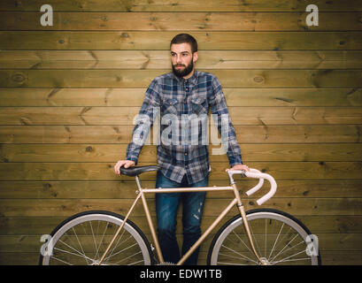Hipster man with his fixie bike on a wooden background Stock Photo