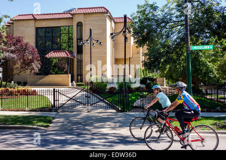 Chicago Illinois,South Side,South Woodlawn Avenue,former Elijah Mohammad residence,mansion,gate,gated,woman female women,bikers,bicycles,biking,riding Stock Photo
