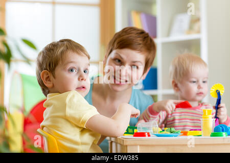 kids and mother playing colorful clay toy at home Stock Photo