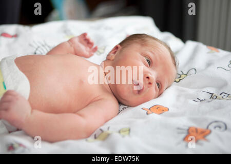 a few days old infant with diaper is in Baby cot Stock Photo