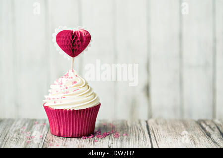 Cupcake decorated with a heart shaped cake pick Stock Photo