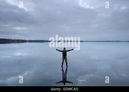 Man standing on frozen ice. Stock Photo