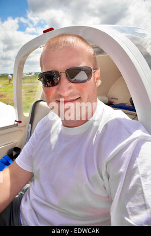 Male pilot sitting in the airplane cockpit Stock Photo