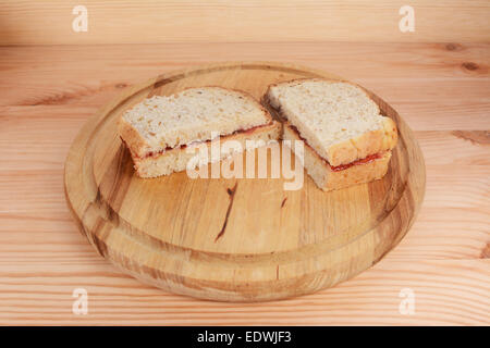 Freshly sliced peanut butter and jam sandwiches on a wooden board Stock Photo