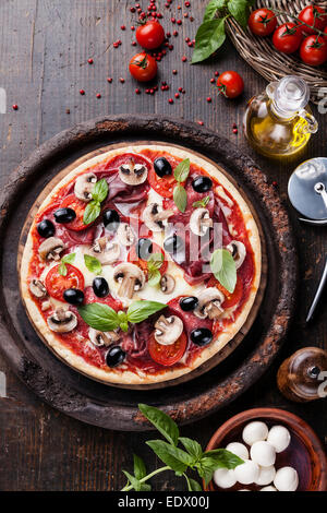 Italian pizza with salami, mushrooms and olives on wooden table Stock Photo