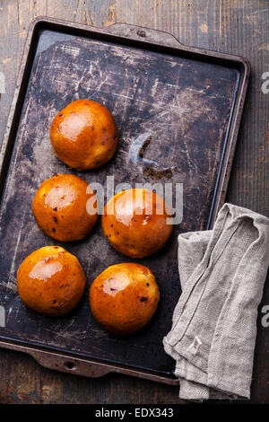 Homemade buns with raisins on Old scratched black dark tray Stock Photo