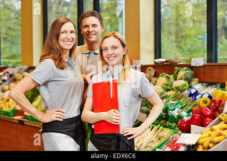 Team of smiling store manager and happy salespeople in a supermarket Stock Photo