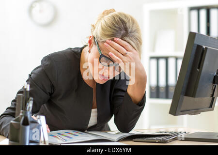thoughtful business lady looking at business papers in office Stock Photo