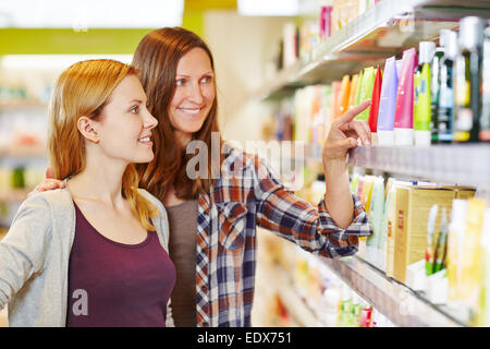 Mother giving her daughter shopping advice in a drugstore Stock Photo