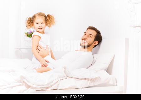 Happy father with his daughter in white pajamas Stock Photo