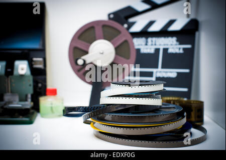 A vintage 8mm movie editing desktop with reels and clapper in out of focus background, vintage color effect Stock Photo