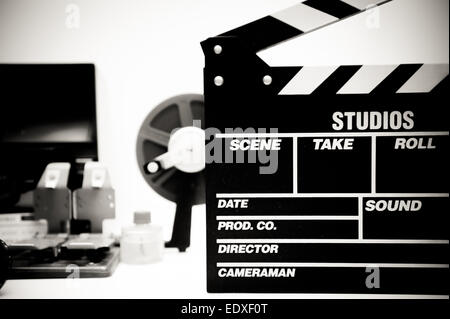 Clapper board with vintage movie editing desktop in black and white in background out of focus Stock Photo