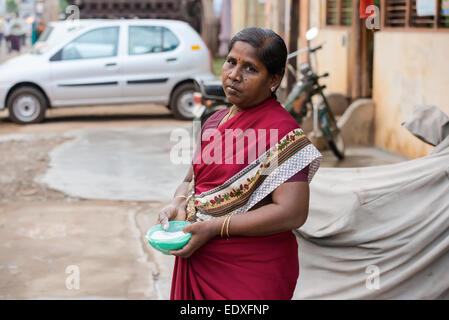 THANJAVOUR, INDIA - FEBRUARY 14: An unidentified woman holding capacity with rice powder drawing on asphalt road. India, Tamil N Stock Photo