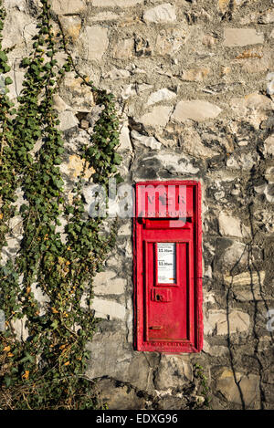 Old red post box in a stone wall at Monsal Dale in the Peak District, Derbyshire. Ivy creeping up the wall. Stock Photo