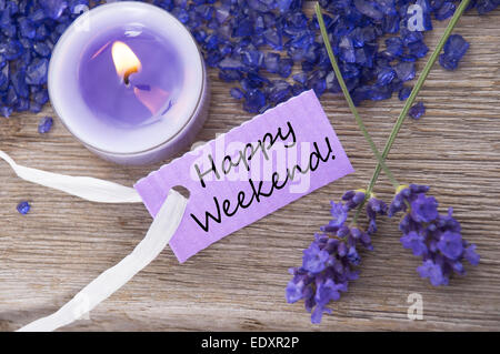 Purple Label With Candle Light And Lavender Blossoms With English Text Be Happy Weekend On Wooden Background With White Ribbon T Stock Photo