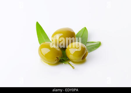 Three pitted green olives with fresh leaves Stock Photo