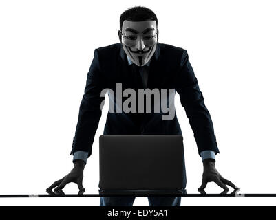 Paris, France - October 30, 2012 : one man dressed and masked as a member of Anonymous underground group member computing computer on October 30, 2012 in Paris ,France Stock Photo