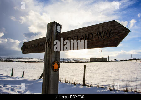 Boulby Mine behind a Cleveland Way sign post. Boulby Mine is a 200 hectare (490-acre) site run by Cleveland Potash, located just southeast of the village of Boulby, on the northeast coast of the North Yorkshire Moors in Redcar and Cleveland, England. It is Europe's second deepest mine at 1,400 metres (4,600 ft) and the deepest in the UK. It produces half of the UK's output of potash, an agricultural fertilizer. As a by-product the mine produces rock salt, used across the region as a de-icing agent on roads in winter conditions. Stock Photo