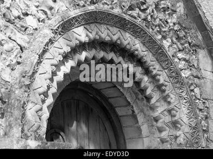 Carved arch with chevrons, stars and grapes believed to date1140s over the south doorway of Tortington Church, West Sussex Stock Photo