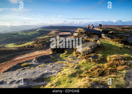 Hikers on Stanage Edge in Peak District during sunset landscape Stock Photo