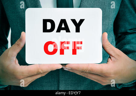 a young businessman showing a signboard with the text day off written in it Stock Photo