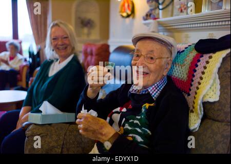 Care home in Bungay Suffolk,England UK. Patient with hat and family and friends woman laughing are model released but not the nursing staff or woman in background on left in this picture.. Stock Photo