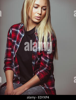 Studio shot of attractive woman looking down. Pretty young blond looking away. Stock Photo
