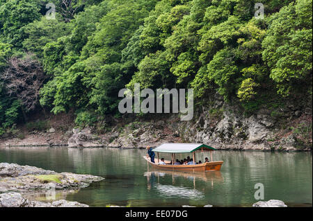 Tourists taking a boat trip along the Katsura River in Arashiyama, Kyoto, Japan Stock Photo