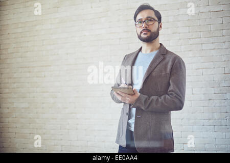 Young businessman making notes in notepad Stock Photo
