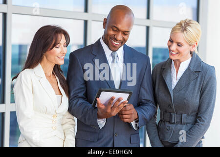African American businessman and two businesswomen, business man, business woman, using tablet computer Stock Photo