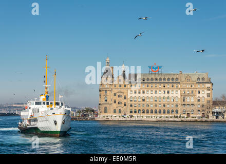 A passenger ferry arriving at Kadikoy on the Asian side of Istanbul with Haydarpasa railway station in the background, Turkey. Stock Photo