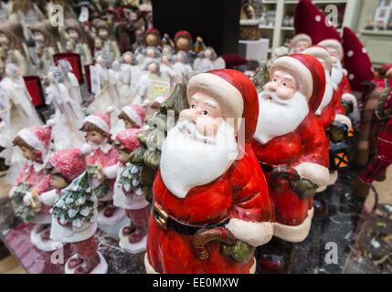 Traditional red Santa Claus doll figure as part of a Christmas festive season shop display of Xmas decorations Stock Photo