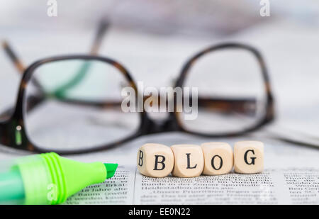 Blog formed by wooden letters, on top of newspapers with glasses and pen Stock Photo