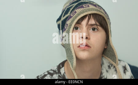 Serious Teenage boy with Autism and Downs Syndrome wearing a Wool Hat Stock Photo