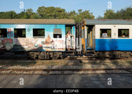 Train Carriage with Western Tourist smoking a cigarette Railway Station in Kanchanaburi Thailand Stock Photo