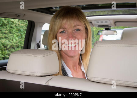 Portrait of a woman sitting in the rear seat of a car Stock Photo