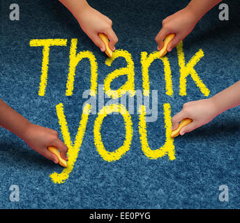 Thank you writing on street pavement by a group of culturally diverse people drawing the words of gratitude with chalk as a community support concept. Stock Photo