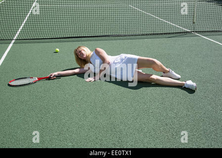 Tennis player on the ground after missing a shot on court Stock Photo