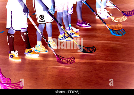 Children boys schoolchildren playing floorball (floor hockey) match in school gym hall with plastic hockey sticks Stock Photo