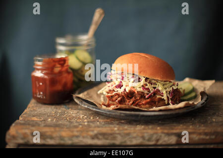 A Pulled Pork Sandwich served with Slaw and pickles. Stock Photo