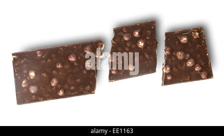 Broken tiles of dark chocolate with whole hazelnuts isolated on white background Stock Photo